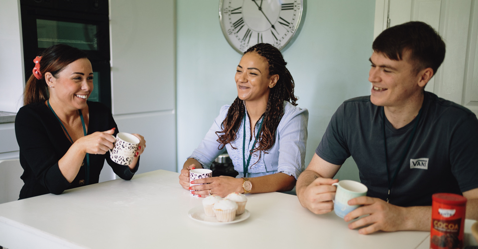 Young people and carer gardening at a home.